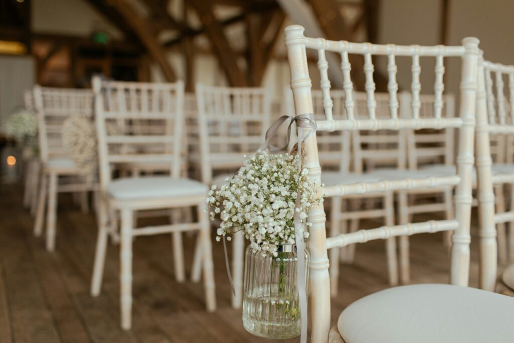 White wedding ceremony chairs placed in rows.
